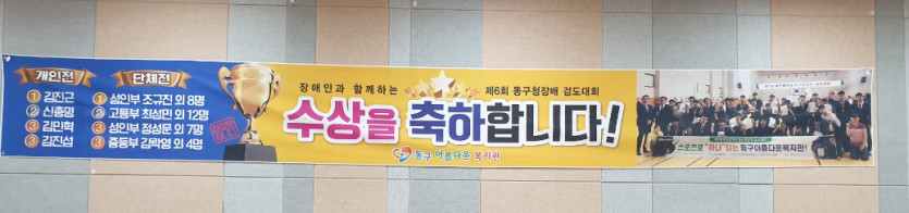 수상을 축하합니다! 라고 적혀진 배너가 걸려있는 벽면 사진