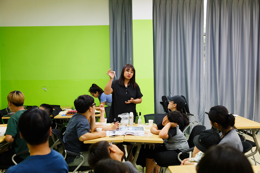 학생들에게 설명을 하는 선생님과 경청하고있는 학생사진