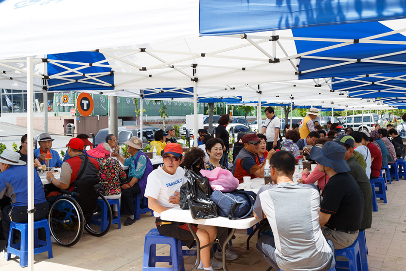 마련된 테이블에서 음식을 먹고있는 이용자들 사진