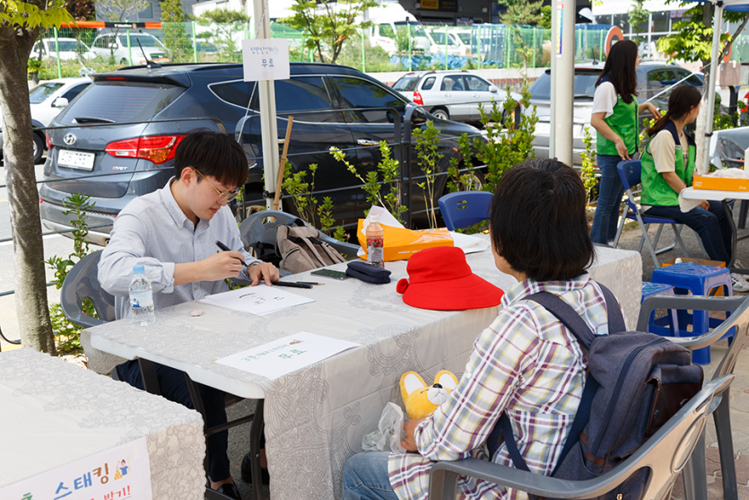 캐리커쳐를 그리고있는 봉사자와 이용자 사진