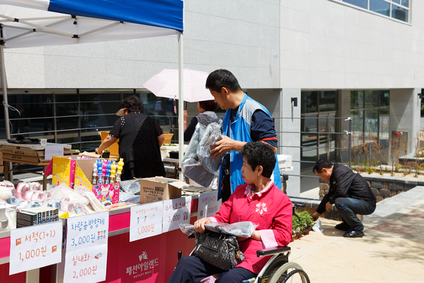 휠체어에 앉아 문구류를 구경하고있는 이용자 사진