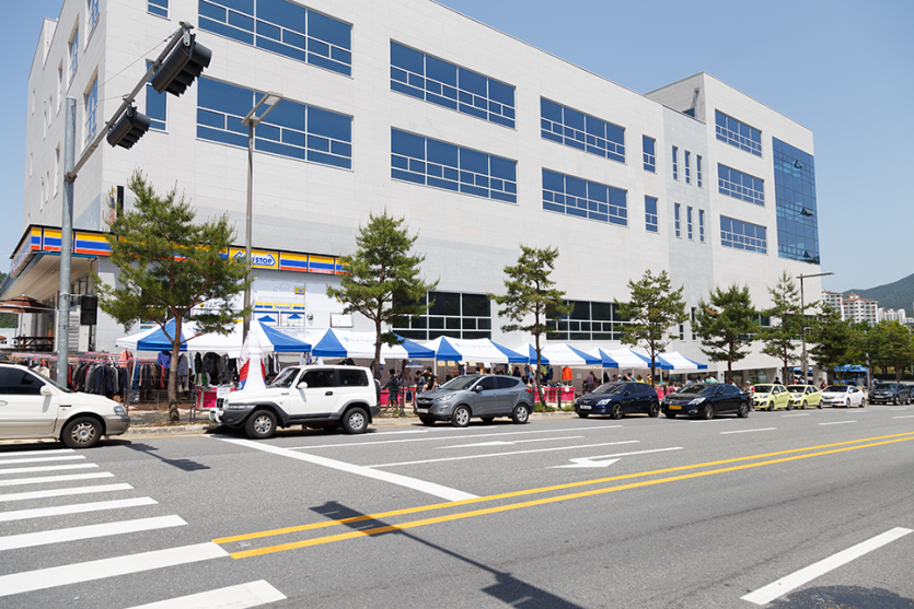 바자회 부스 앞에 차들이 주차되어있는 모습 사진