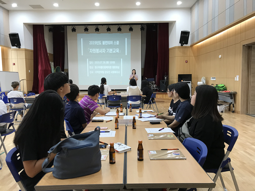 교육생들이 테이블에 앉아 자원봉사자기본교육을 듣고있는 모습 사진