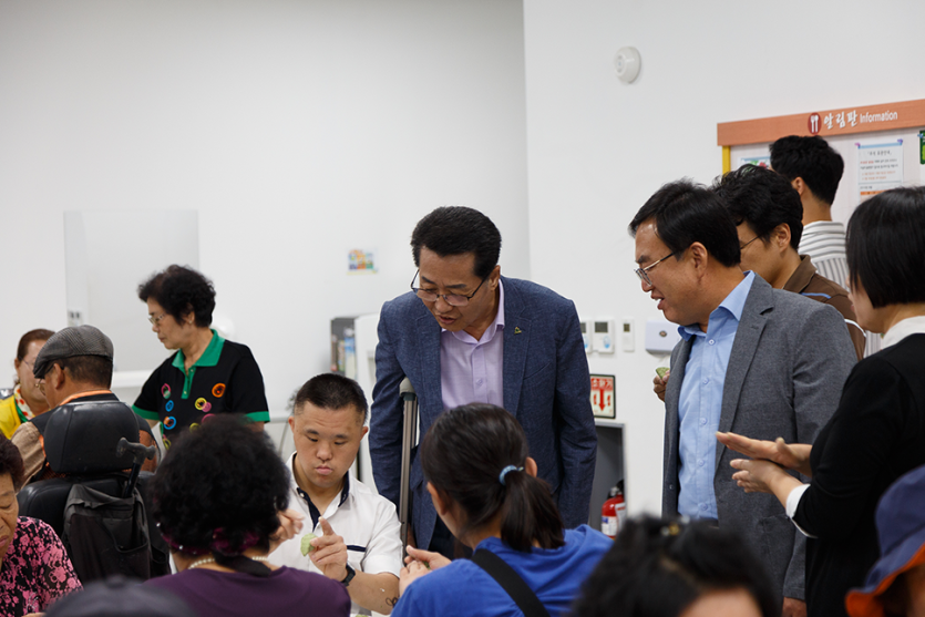 송편빚는 모습을 보고있는 복지관 관계자들 사진