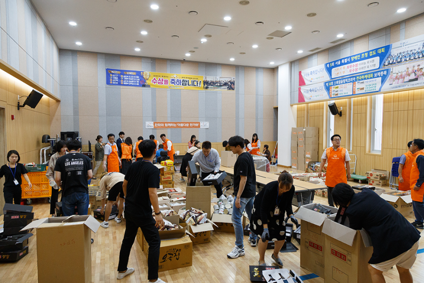 행사물품들을 박스에 포장하고있는 봉사자들의 모습 사진