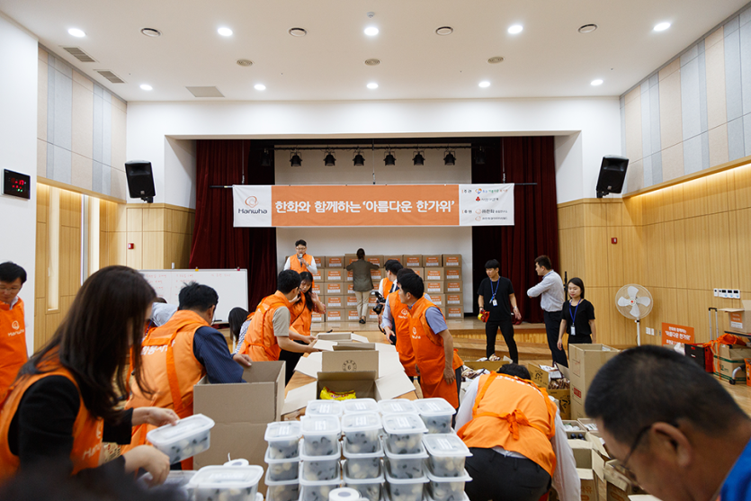 용기에 담겨진 송편과 행사준비로 바쁘게 움직이고있는 봉사자들 사진