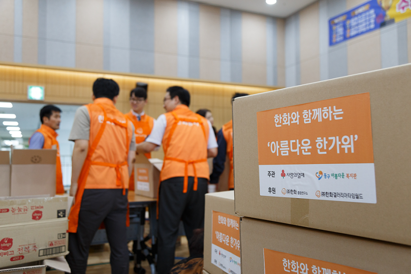 정리되어있는 박스들과 봉사자들의 뒷모습 사진