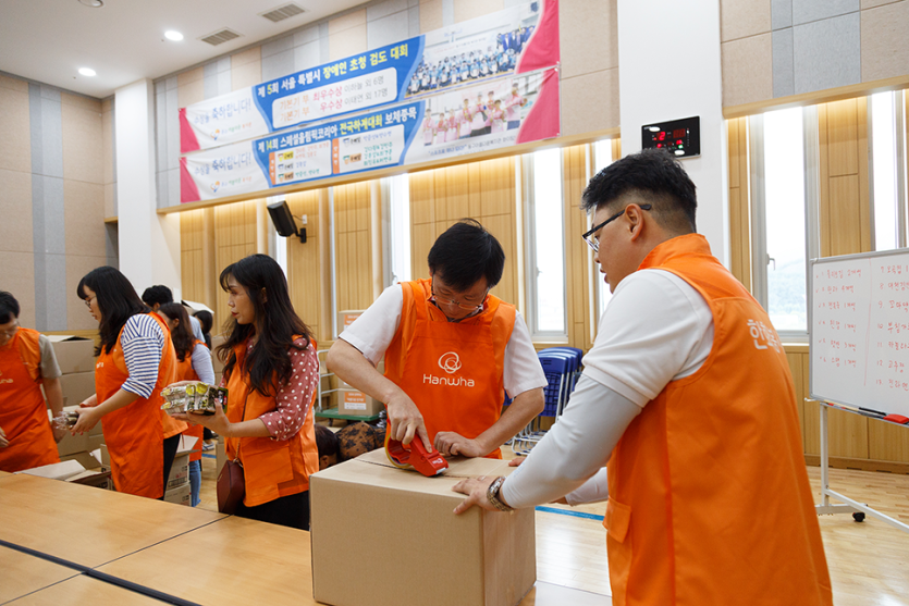 박스를 테이프로 붙이고있는 봉사자들 사진