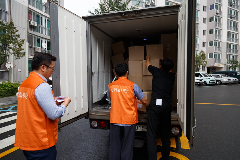 박스를 트럭에 싣고있는 봉사자들 사진